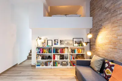 a living room with a book shelf filled with books at Stay U-nique Apartments Travessera II in Barcelona