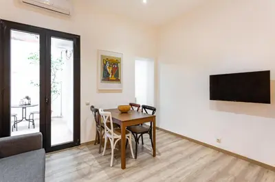 a dining room with a table and a tv at Stay U-nique Apartments Travessera II in Barcelona