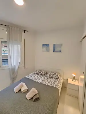 a bedroom with a bed with two towels on it at Family apartment close to Parc Güell in Barcelona