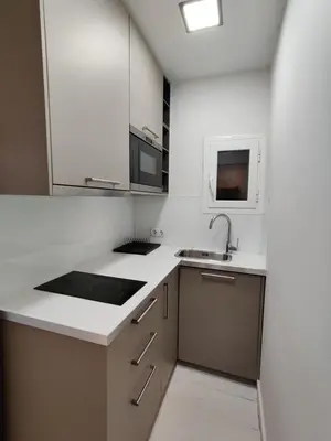 a kitchen with white countertops and a sink at Family apartment close to Parc Güell in Barcelona