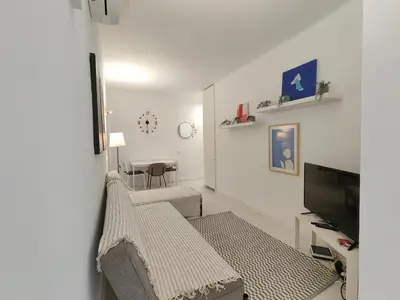 a living room with a couch and a television at Family apartment close to Parc Güell in Barcelona