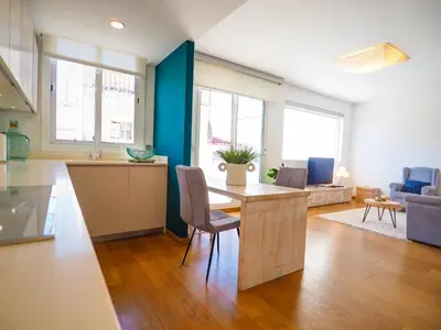 a kitchen and living room with a table and chairs at Elite Bonaire Penthouse by Hello Homes Sitges in Sitges