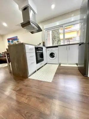 a kitchen with white cabinets and a sink and a dishwasher at Arena Castelldefels in Castelldefels