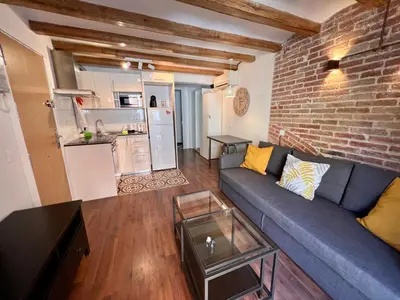 a living room with a blue couch and a brick wall at Sagrada Familia- Excelente Ubicación in Barcelona
