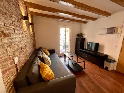 a living room with a couch and a brick wall at Sagrada Familia- Excelente Ubicación in Barcelona