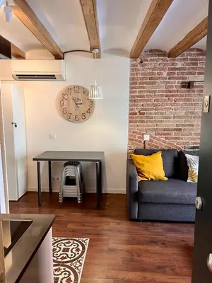 a living room with a couch and a brick wall at Sagrada Familia- Excelente Ubicación in Barcelona