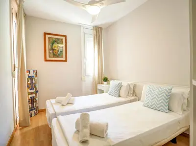 a bedroom with two beds and a couch in it at Golden Sands by Hello Homes Sitges in Sitges