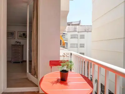 a red table on a balcony with a plant on it at Golden Sands by Hello Homes Sitges in Sitges