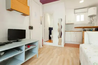 a room with a bed and a television on a table at SAGRADA FAMILIA APARTAMENT in Barcelona
