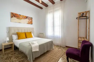 a bedroom with a bed and a purple chair at CENTRIC APARTMENT GAUDI in Barcelona