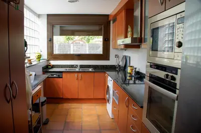 a kitchen with wooden cabinets and a sink and a window at Casa Martina in Cardedeu
