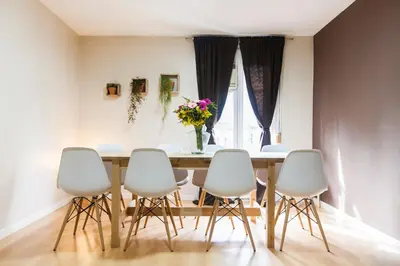 a dining room table with white chairs and a vase of flowers at Be Barcelona Plaza Catalunya in Barcelona