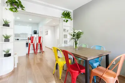 a dining room with a table and colorful chairs at Be Barcelona Eixample Arco del Triunfo in Barcelona