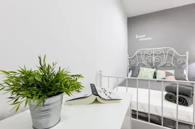 a white room with a crib and a potted plant at Be Barcelona Eixample Arco del Triunfo in Barcelona