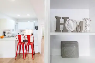 a white kitchen with red chairs and a table at Be Barcelona Eixample Arco del Triunfo in Barcelona