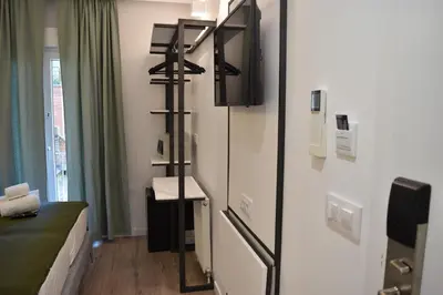 a room with a refrigerator with a tv on it at Casp Green House in Barcelona