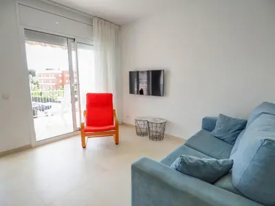 a living room with a blue couch and a red chair at Sitges with pool near beach by Hello Homes Sitges in Sitges