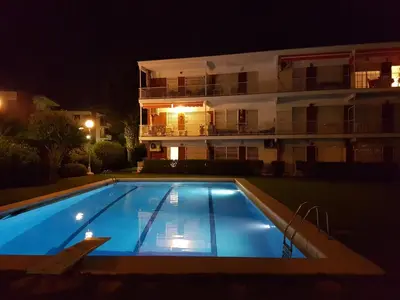 a swimming pool in front of a building at night at Sitges with pool near beach by Hello Homes Sitges in Sitges