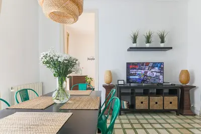 a dining room with tables and chairs and a television at Be Barcelona Eixample Universidad in Barcelona