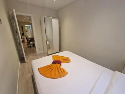 a white bed with two orange robes on it at BARCELONA DUPLEX DE 3 HABITACIONES in Hospitalet de Llobregat