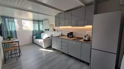 a kitchen with a refrigerator and a couch in a room at Topdown Apartments in Hospitalet de Llobregat