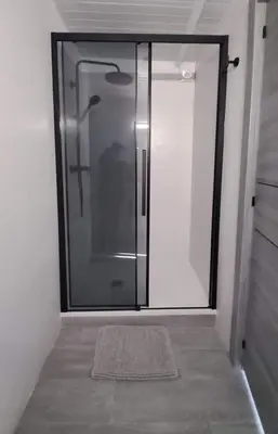 a glass shower door in a room with a rug at Topdown Apartments in Hospitalet de Llobregat