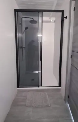 a glass shower door in a room with a rug at Topdown Apartments in Hospitalet de Llobregat