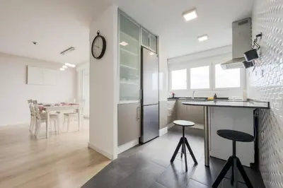 a kitchen with a counter and a clock on the wall at Impresionante Apartamento delante del Mar in Vilassar de Mar