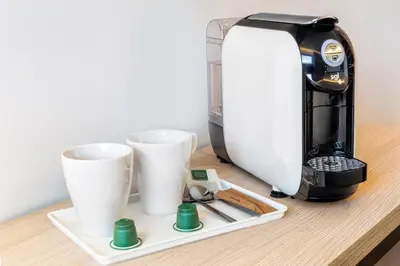 a coffee maker and two cups on a table at B&B HOTEL Barcelona Viladecans in Viladecáns
