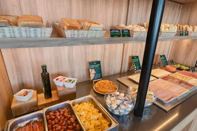 a buffet with different types of bread and other food at B&B HOTEL Barcelona Viladecans in Viladecáns