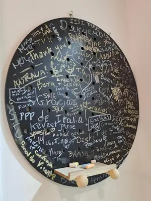 a black plate with writing on a wall with a table at AEROPUERTO BARCELONA -Mi colibrí in El Prat de Llobregat