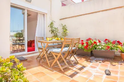a patio with a table and chairs and flowers at Atic Barcelona in Barcelona