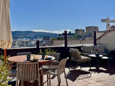 a patio with a table and chairs and an umbrella at Atic Barcelona in Barcelona