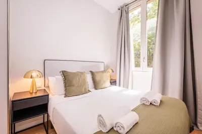 a bedroom with a large white bed with towels on it at Sweett - La Villarroel in Barcelona