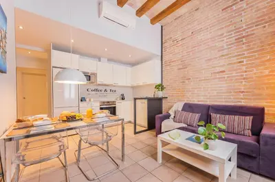a kitchen and living room with a couch and a table at Sweett - La Villarroel in Barcelona