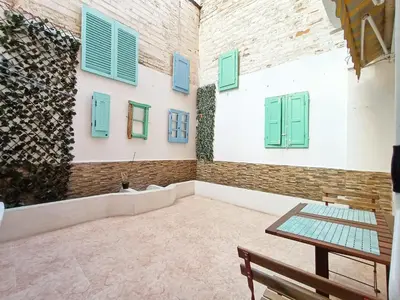 a room with green shuttered windows and a table at COLORS FIRA GRAN VIA in Hospitalet de Llobregat