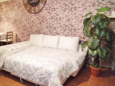 a bedroom with a bed and a brick wall at COLORS FIRA GRAN VIA in Hospitalet de Llobregat