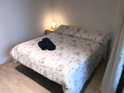 a bedroom with a bed with a white comforter at Llull Home in Sant Adria de Besos