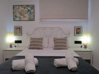 a bedroom with a large white bed with two pillows at Elegante apt. p/4 pax a 1 min de la Playa con WiFI in Arenys de Mar