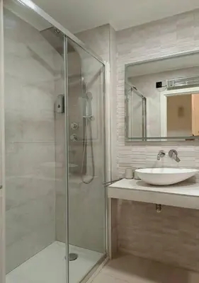 a bathroom with a glass shower and a sink at Elegante apt. p/4 pax a 1 min de la Playa con WiFI in Arenys de Mar