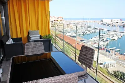a balcony with a table and chairs and a view of a harbor at Elegante apt. p/4 pax a 1 min de la Playa con WiFI in Arenys de Mar
