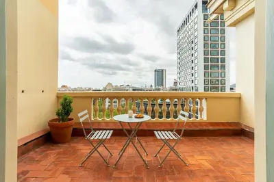 a balcony with a table and chairs on a building at Casa Gracia Apartments in Barcelona