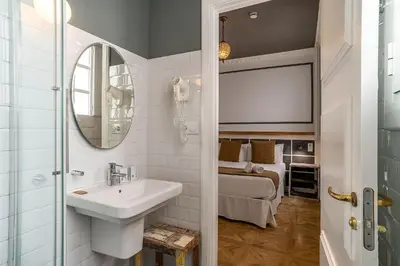 a bathroom with a sink and a mirror and a bed at Casa Gracia Apartments in Barcelona