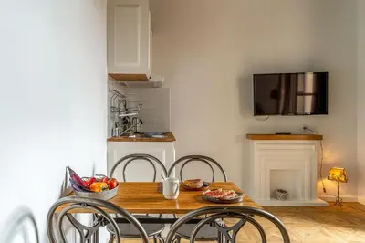a dining room table with chairs and a television on a wall at Casa Gracia Apartments in Barcelona