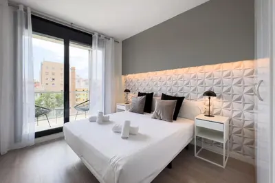 a bedroom with a large white bed and a large window at chicStays Apartment Ciutadella Park in Barcelona