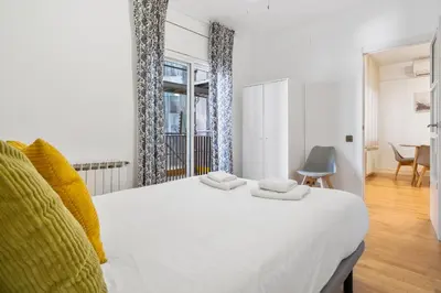a bedroom with a white bed with two towels on it at Plaza Espanya Apartment in Barcelona