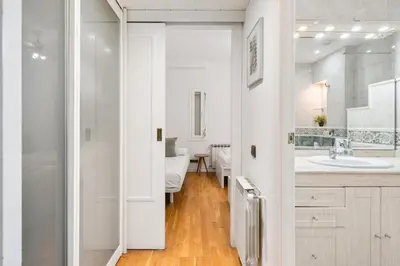 a white bathroom with a sink and a mirror at Plaza Espanya Apartment in Barcelona