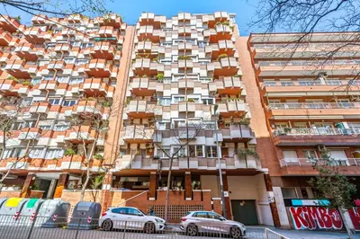 a tall building with cars parked in front of it at Plaza Espanya Apartment in Barcelona