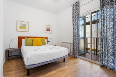 a bedroom with a bed and a large window at Plaza Espanya Apartment in Barcelona