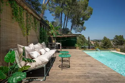 a couch sitting on a deck next to a swimming pool at THE LOFT - with private pool & jacuzzi in Corbera de Llobregat